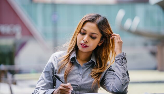 sitting-woman-reading-and-holding-pen-2029796